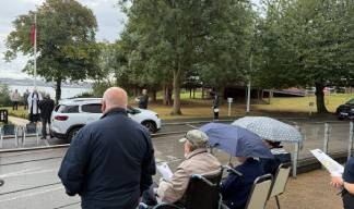 Residents braving the wet weather during the service at the Park Image:Residents braving the wet weather during the service at the Park
